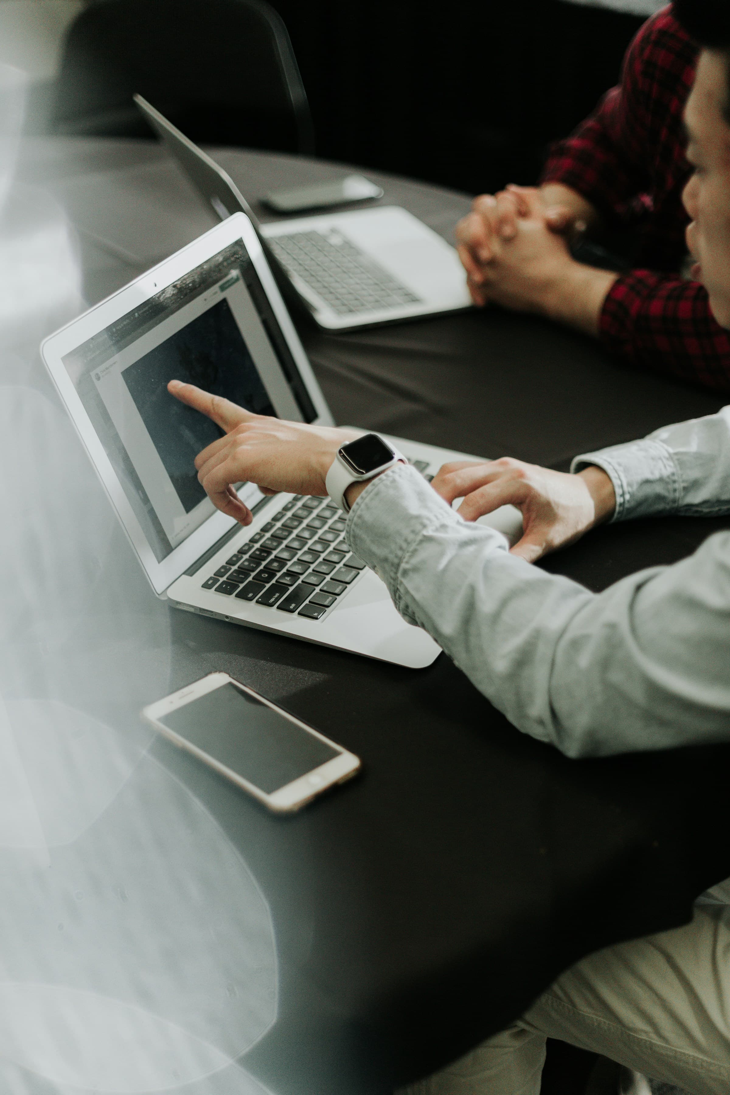 Person pointing to a laptop screen during a working session
